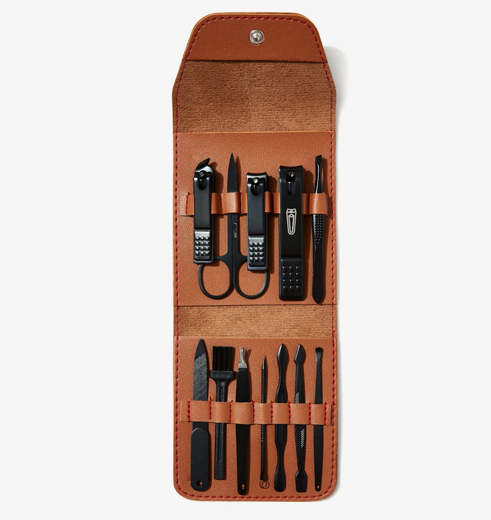 A collection of nail grooming tools including nail clippers, file, scissors, tweezers, cuticle pusher, and other items, neatly arranged in an open brown case.